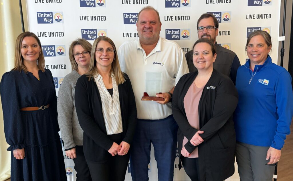 Centennial Homes team members at a United Way event in front of a Live United backdrop