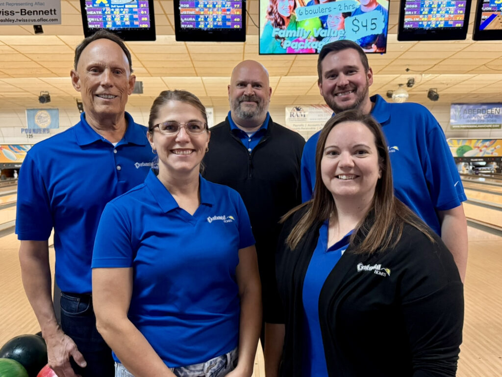 Centennial Homes team members in blue shirts at a Junior Achievement Bowl-A-Thon