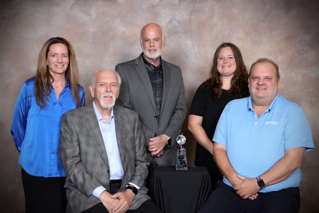 Five Centennial Homes team members posing with an award trophy
